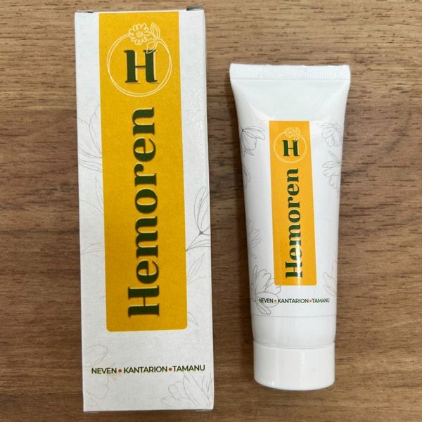 Belo-rumena škatlica in tuba kreme Hemoren na leseni mizi