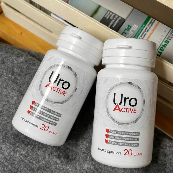 Dve beli plastenki Uro Active z napisom 20 tablets na sivi tkanini